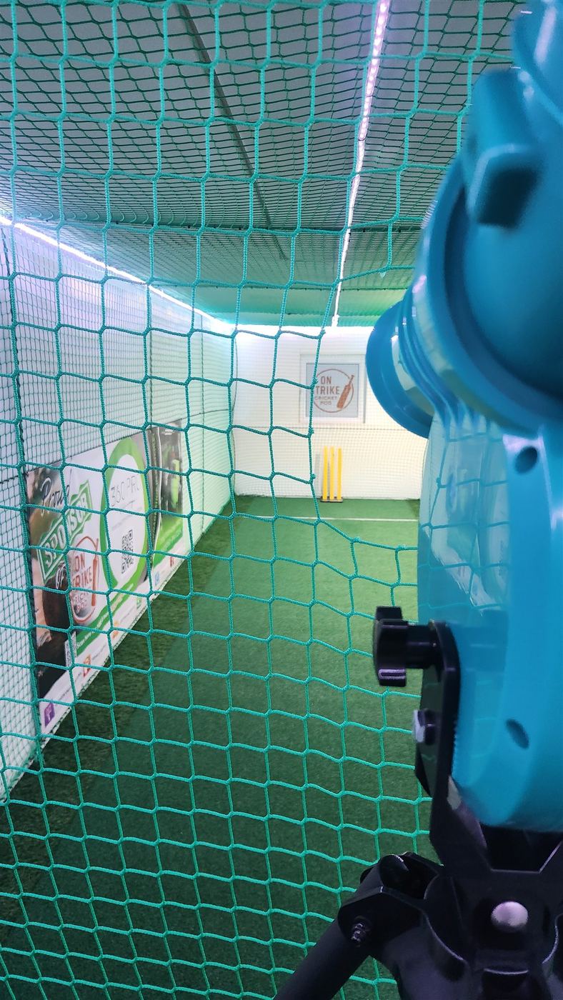 View through the indoor cricket net towards the wicket and flexible stumps View through the indoor cricket net towards the wicket and flexible stumps