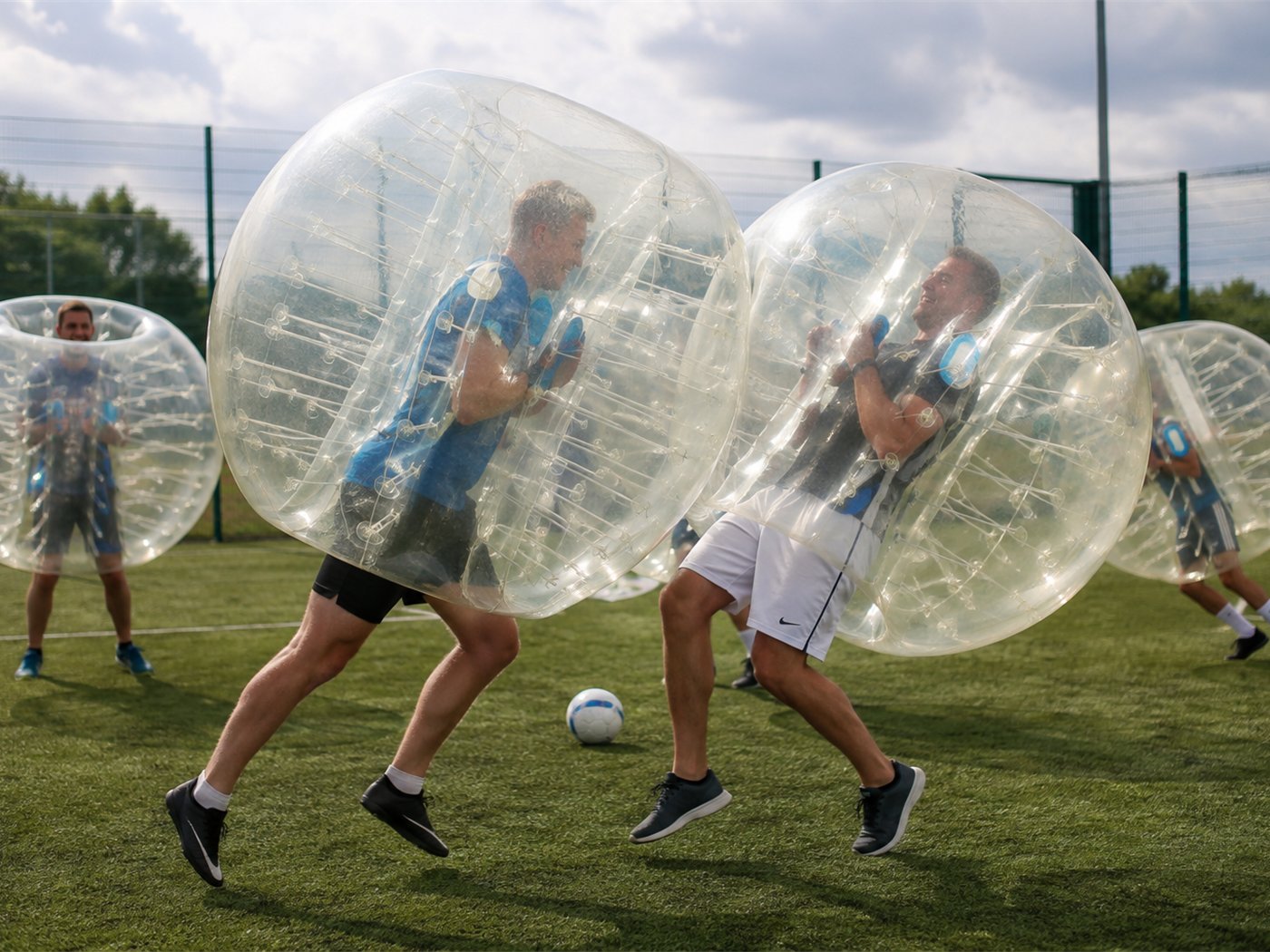 Adults playing Zorb Wars bubble football on a 3G pitch Adults playing Zorb Wars bubble football on a 3G pitch